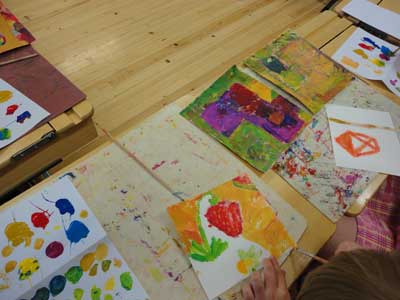 children and parents are painting a part of their environment
